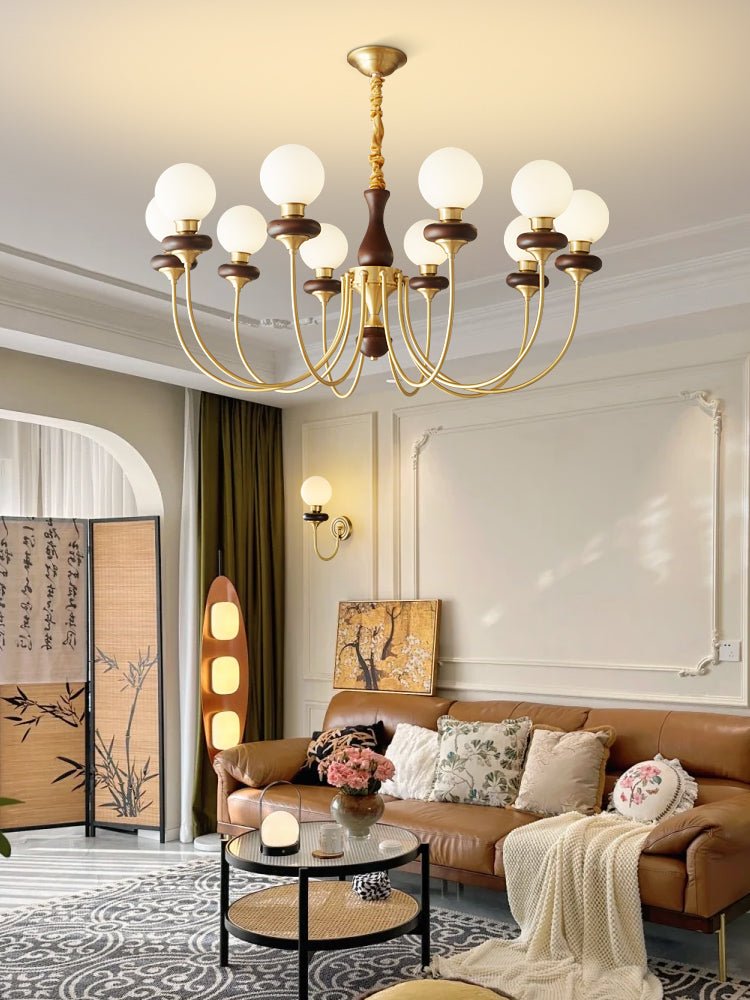 Chandelier lit in a pale room above a sofa and a low coffee table