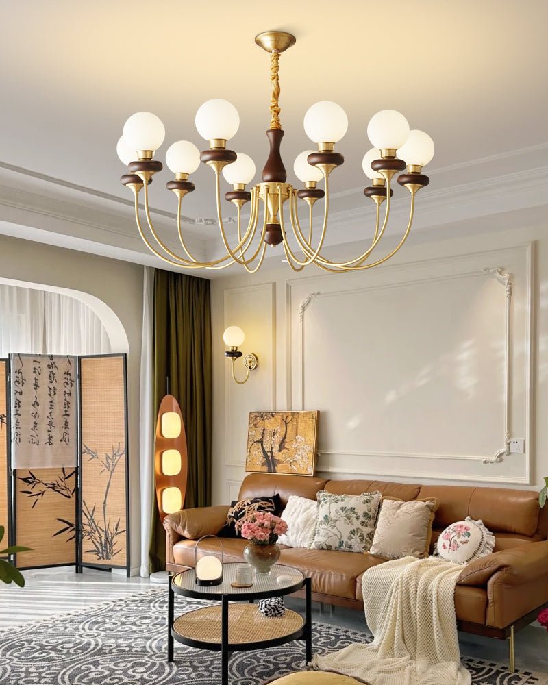 The fitting lit above a sofa and a round table with flowers on it