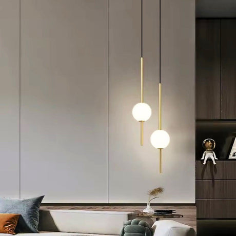 Two brass stems with globes above a dining area with a dark cabinet wall