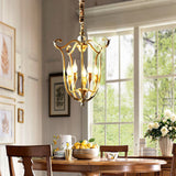 The scroll frame lit above a round dining table with fruit, flowers and a bay window