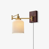 Brass plug in wall sconce with a ceramic shade and a cord running down