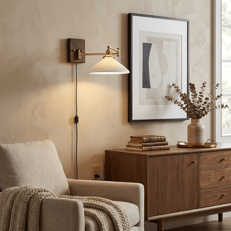 Plug in sconce lit above a walnut dresser beside a framed print