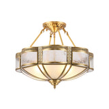 Brass semi flush mount ceiling light with milk glass panels in a cast brass frame