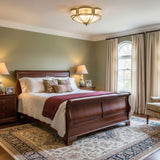 Brass and milk glass ceiling light in a bedroom with a sleigh bed