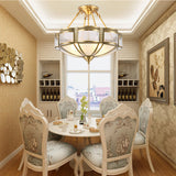 Brass and milk glass ceiling light above a round dining table