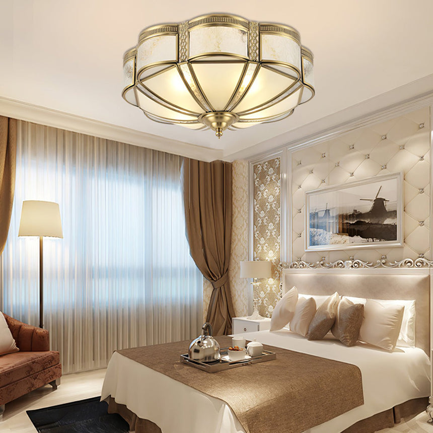 Brass and milk glass ceiling light in a bedroom with gold walls