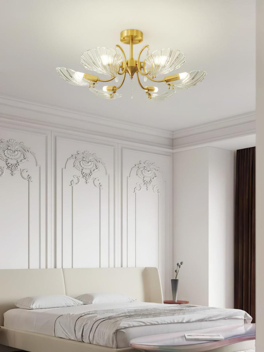Shell shade ceiling light above a bed with a wood headboard