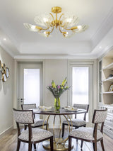 Shell shade ceiling light above a round dining table with chairs