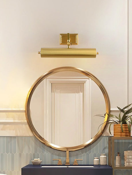 Brass tube above a round mirror over a deep blue vanity with candles