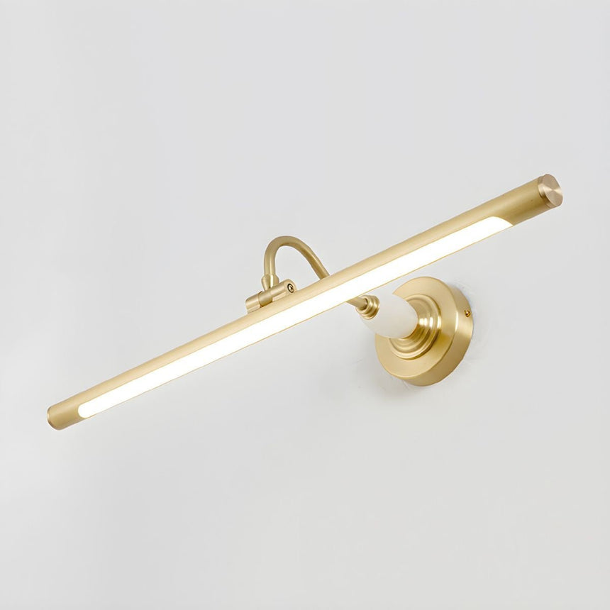 The brass version lit, the tube bright under its curved arm on a pale wall