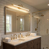 Brass bar lit above a wide mirror over a double basin vanity in a tiled bathroom