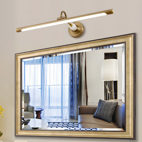 Brass bar lit above a gilt framed mirror reflecting a curtained window and a lamp