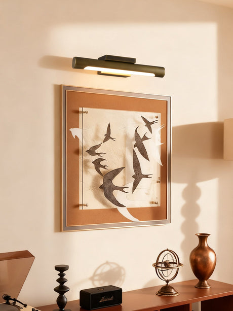 Bronze bar lit over a framed bird print above a desk with a globe