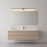 Slim rod lit above a long mirror over a pale oak vanity unit with a basin