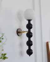 The black bead column at an angle, the brass arm behind the globe