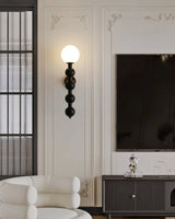 Sconce lit above a fluted console beside two pale armchairs