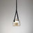 The amber plated glass shade on its leather strap on a plain background