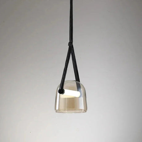 The amber plated glass shade on its leather strap on a plain background