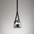 The gray plated glass shade on its leather strap on a plain backdrop
