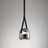The gray plated glass shade on its leather strap on a plain backdrop