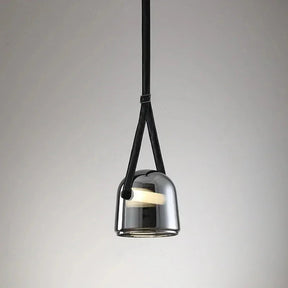 The gray plated glass shade on its leather strap on a plain backdrop