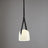 The milk white glass shade on its leather strap on a plain background