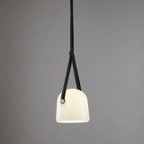 The milk white glass shade on its leather strap on a plain background
