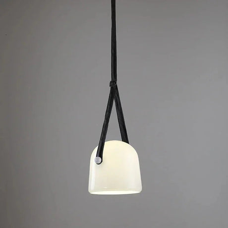 The milk white glass shade on its leather strap on a plain background