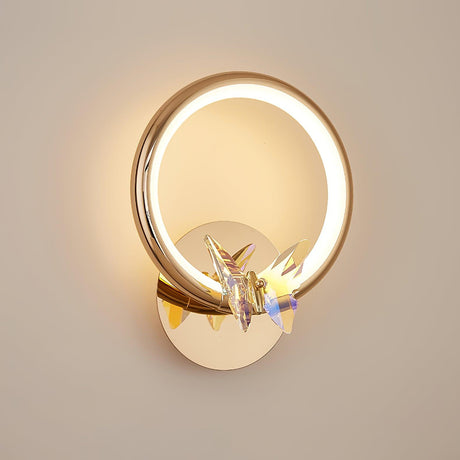 The ring lit warm on a beige wall, the butterfly catching the light