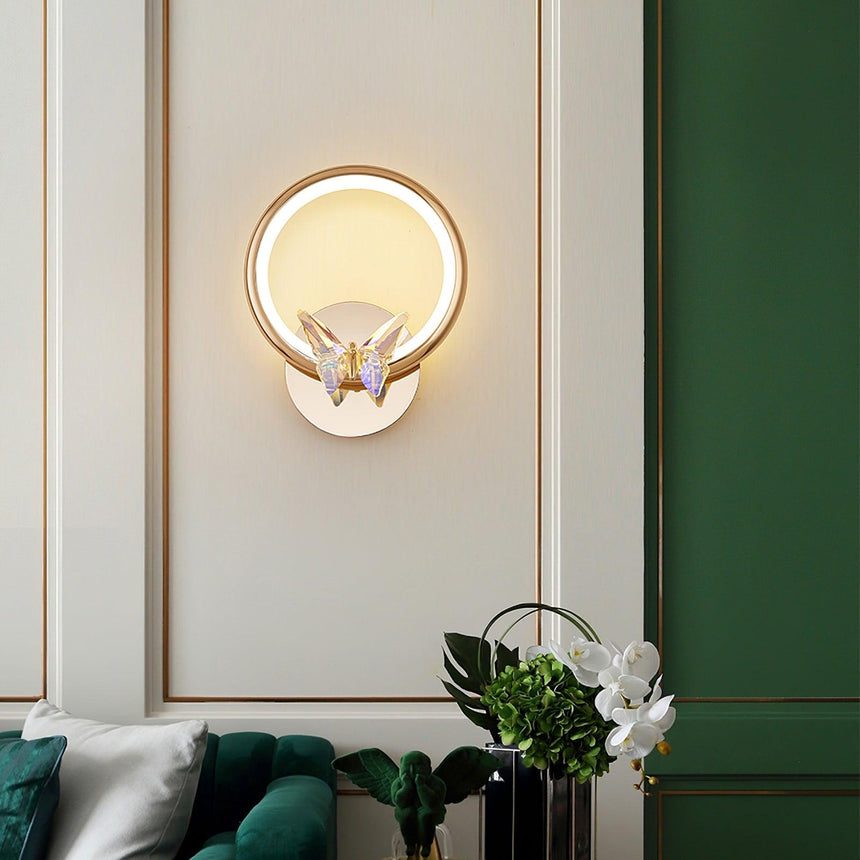 The butterfly ring on a paneled wall above a green sofa and a vase of orchids