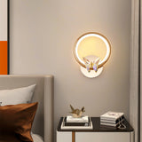 The butterfly ring lit above a black nightstand with books beside a bed