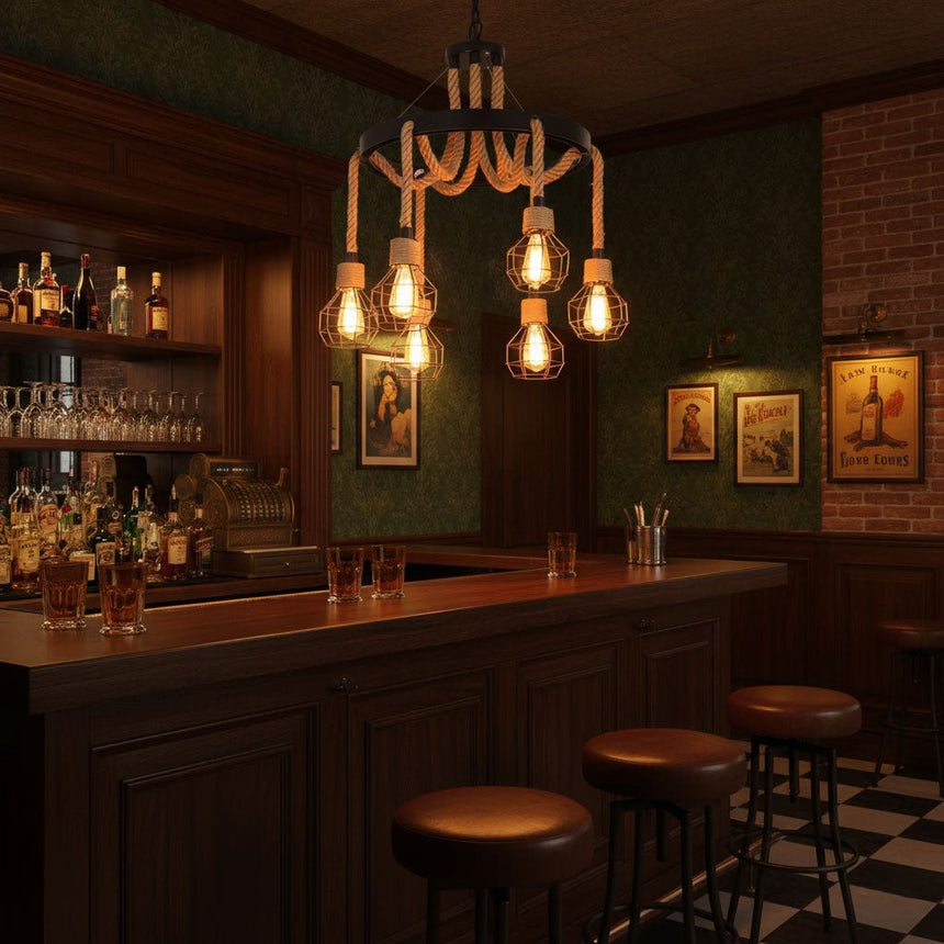 Chandelier lit above a dark bar counter with stools and bottles