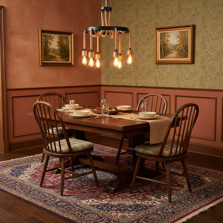 Chandelier lit above a wood dining table with spindle back chairs