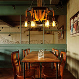 Chandelier lit above a long wood table with chairs on both sides