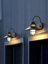 Two sconces lit above a pair of doors on dark blue ribbed cladding