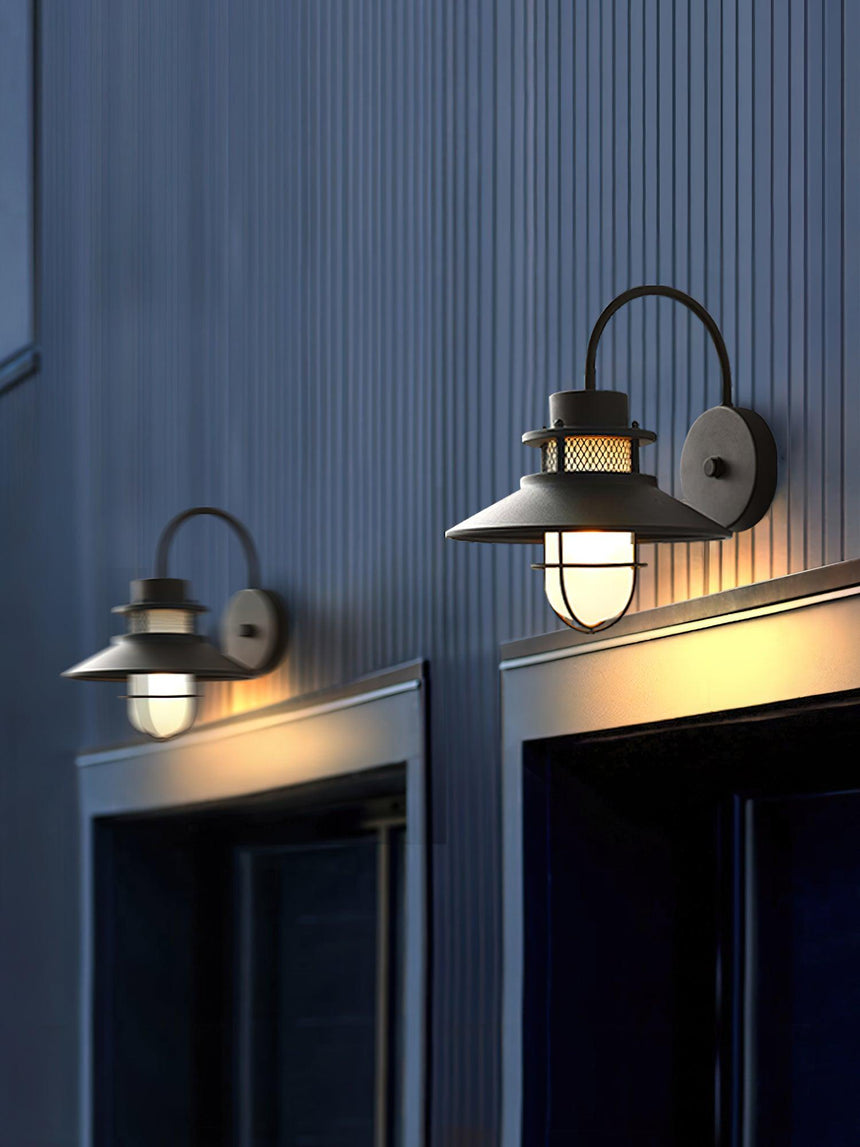 Two sconces lit above a pair of doors on dark blue ribbed cladding