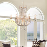 Lit in front of tall arched windows in a room with a sofa and a view of trees