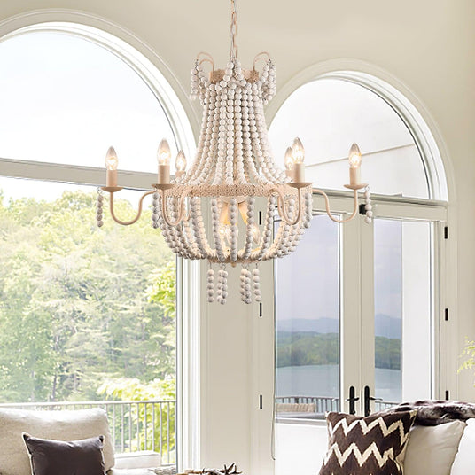 Lit in front of tall arched windows in a room with a sofa and a view of trees