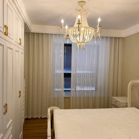 Hung in a bedroom above the bed with long sheer curtains at the window