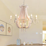 Hung above a table set with candles beside two framed prints on a white wall