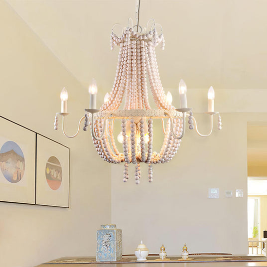 Hung above a table set with candles beside two framed prints on a white wall