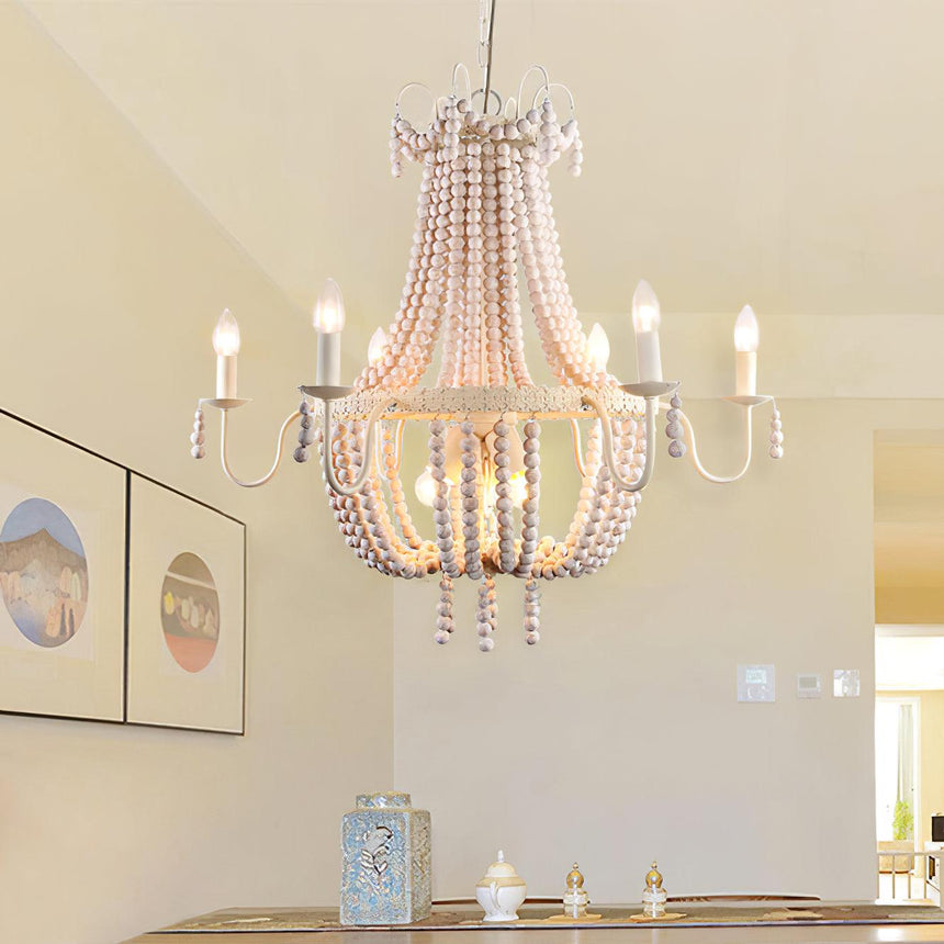 Hung above a table set with candles beside two framed prints on a white wall