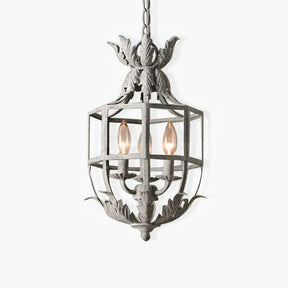 A pale metal cage lantern with a leaf crown on top and three candle lamps inside