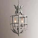 The cage lit against a pale wall, three candle lamps burning inside the frame