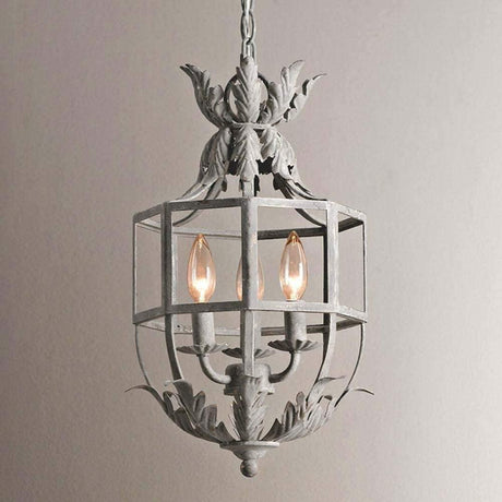 The cage lit against a pale wall, three candle lamps burning inside the frame