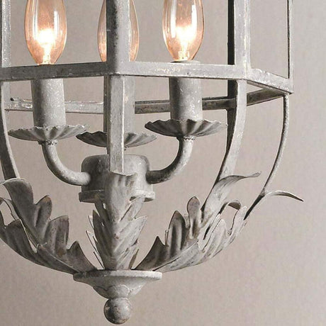 The three candle arms above the curled leaf base inside the cage