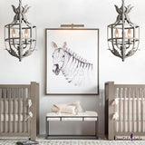 A pair of them lit in a nursery either side of a large framed animal print