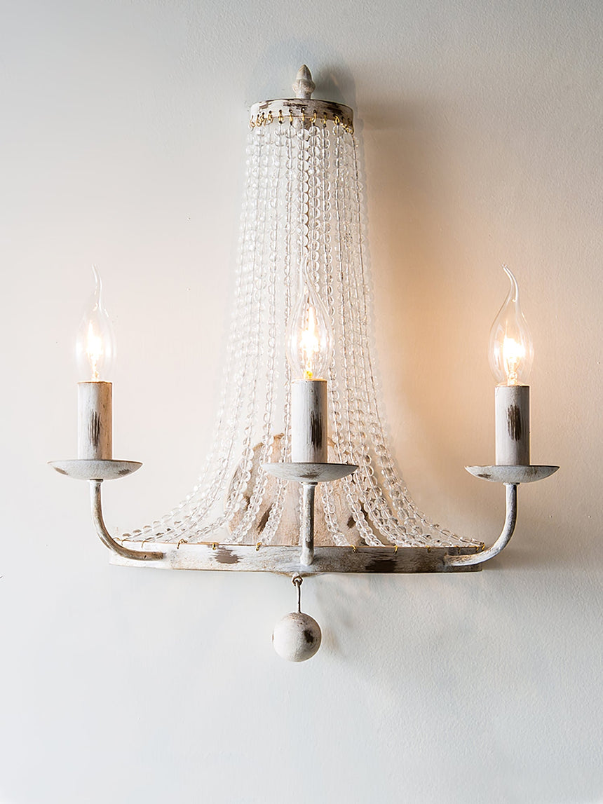 The three arm version lit, candle bulbs glowing in front of the bead strands