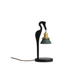 Black heron candle warmer lamp on a plain ground with a twisted cord