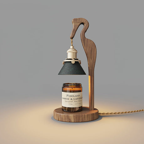 Heron lamp lit above a candle jar, the green shade glowing warm